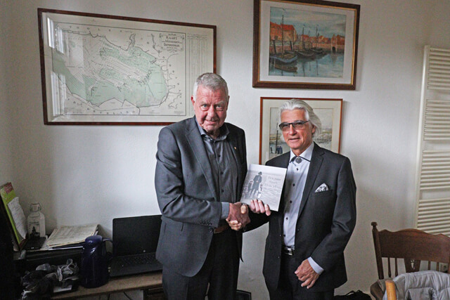 Voorzitter Kees Coppens (l) ontvangt het eerste exemplaar van Jacques van Eekelen.